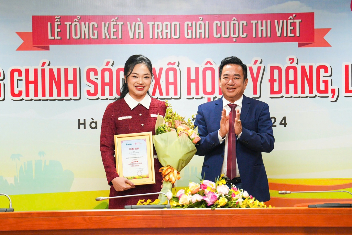 Ông Huỳnh Văn Thuận - Phó Tổng Giám đốc NHCSXH, Phó Trưởng ban Thường trực Ban Tổ chức Cuộc thi lên trao giải Nhất cho tác giả Võ Tạ Hương Giang 