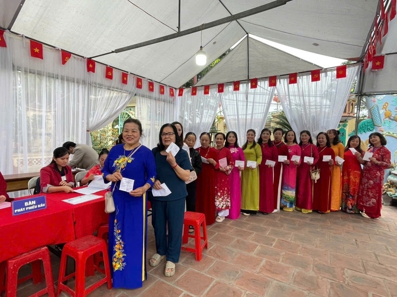 Chị em phụ nữ phường Ngọc Hồi (Hà Nội) trong tà áo dài truyền thống, cầm lá phiếu trên tay thể hiện rõ ý thức chính trị và sự quan tâm tới các vấn đề của địa phương - Ảnh: VGP/Gia Huy