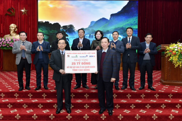 A group of people holding a sign    Description automatically generated